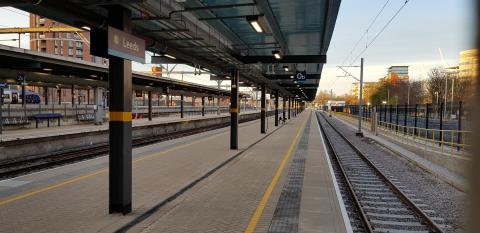 View of platform and rail track with city scape in the distance.