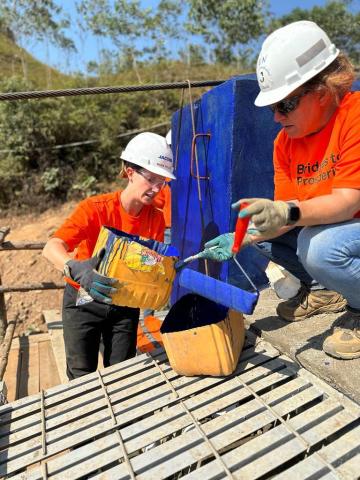 Pouring paint into a bucket at B2P site