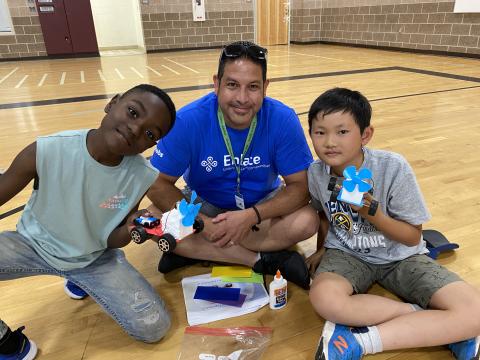 Jacobs STEAM volunteer with two young male students