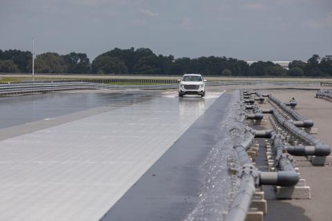 Vehicle drives on SunTrax test track with wet conditions