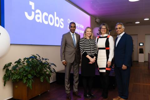 Four people standing in front of screen with Jacobs logo on it