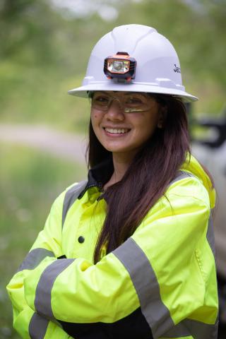 Female wastewater engineer in yellow PPE coat and white hardhat