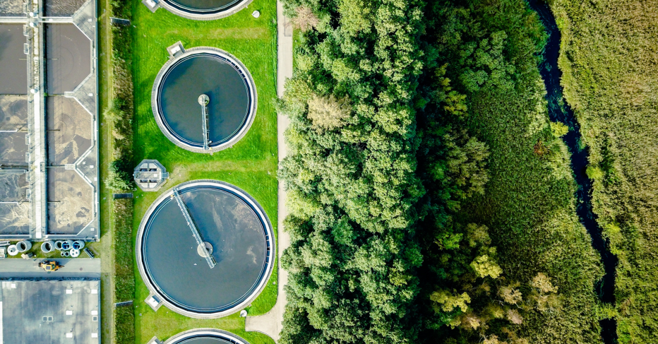 Stock image depicting water treatment facility, surrounded by bright greenery