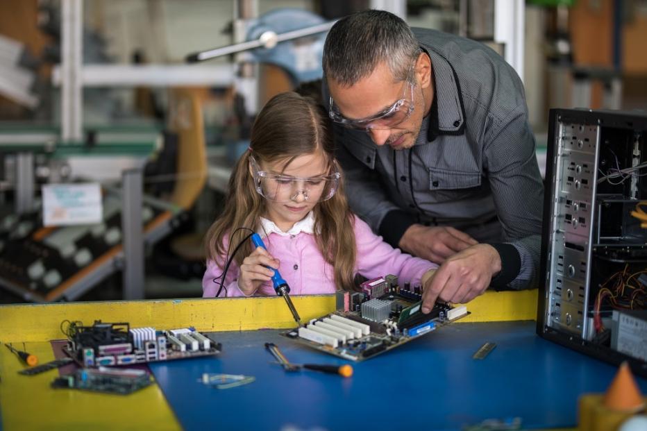 Man works with young girl on a electronics project