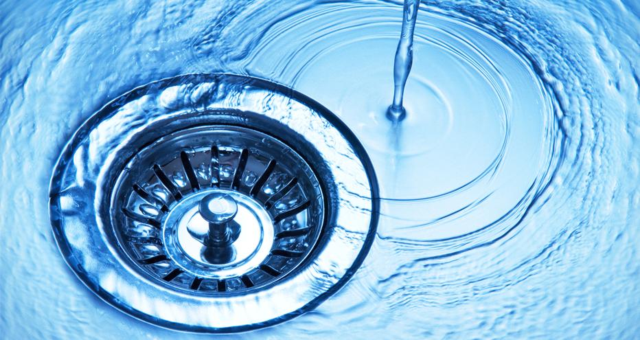 Stock image of water dripping down a drain