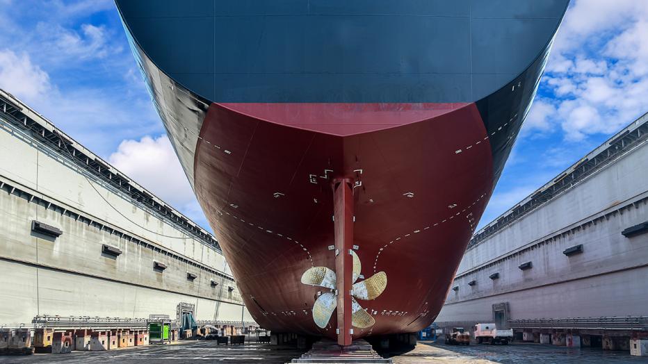 Underside of large ship with a fan at a dock