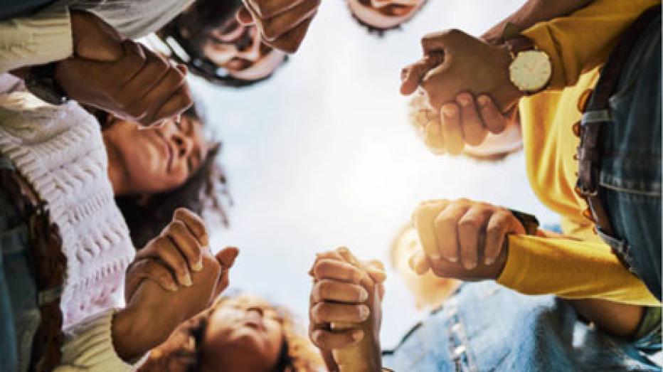 People standing in a circle holding hands