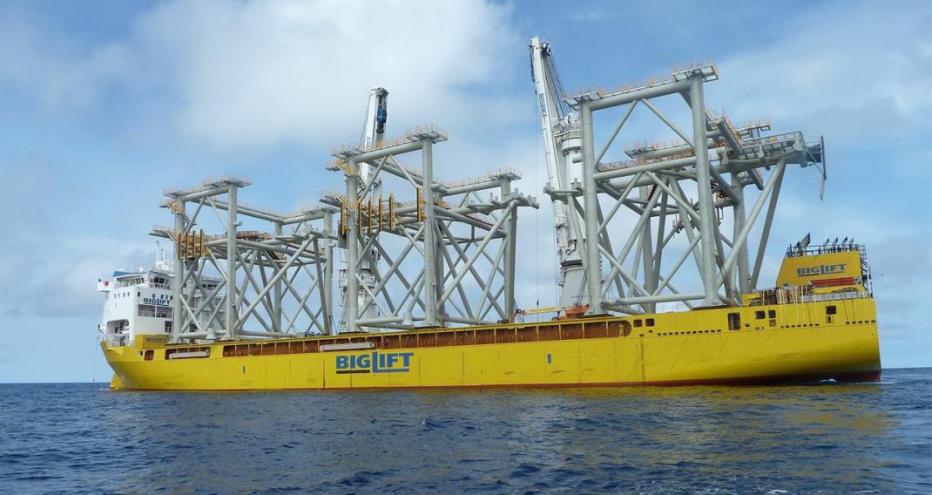 Yellow barge transporting three modules to the construction site 