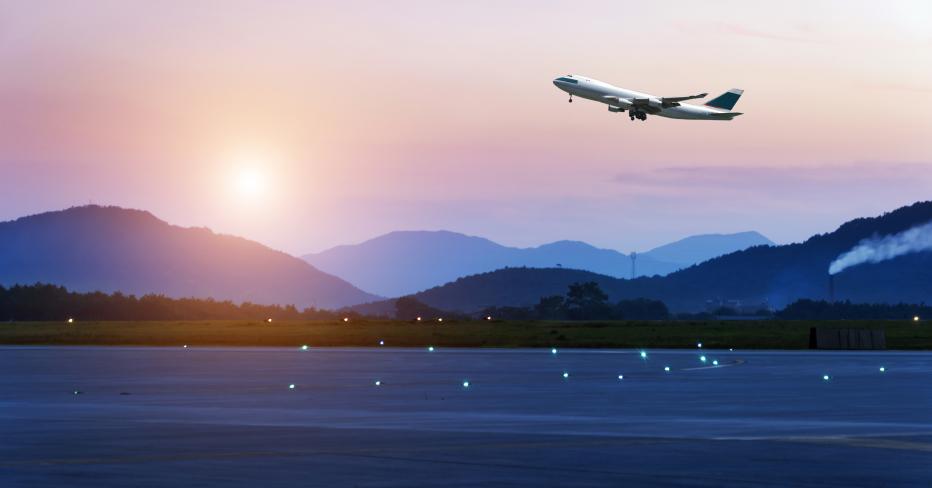 Airplane taking off in front of mountains