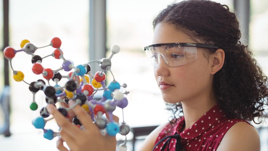 Girl with protective goggles holding 3D model
