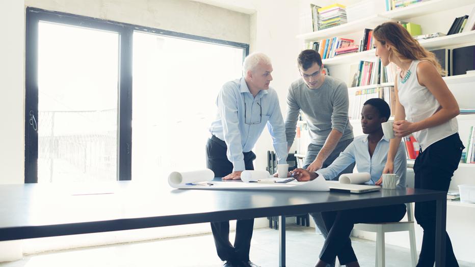 Four people working at a desk