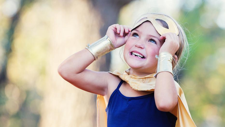 Young blond girl child in a super hero costume