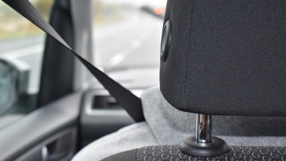 Car headrest with seatbelt