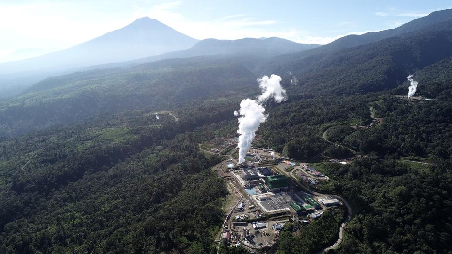 Aerial view of the Muara Laboh Geothermal Power Plant with mountains in background