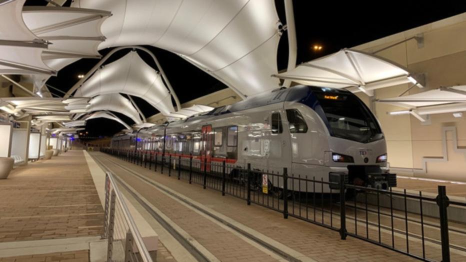 Silver commuter rail train at a stop 