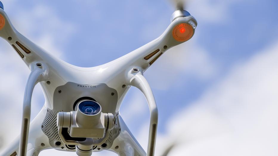 White drone flying in a blue sky