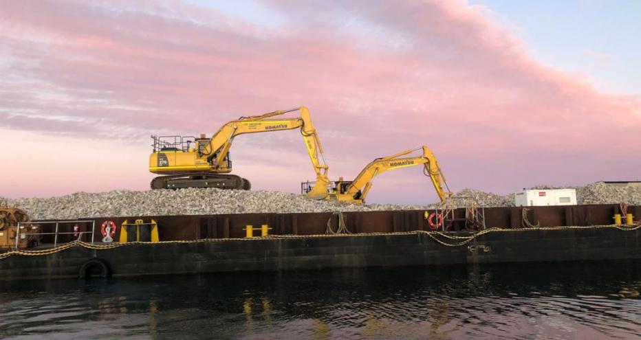 Two excavators at work on Windara Reef construction with pink sky at sunset behind them