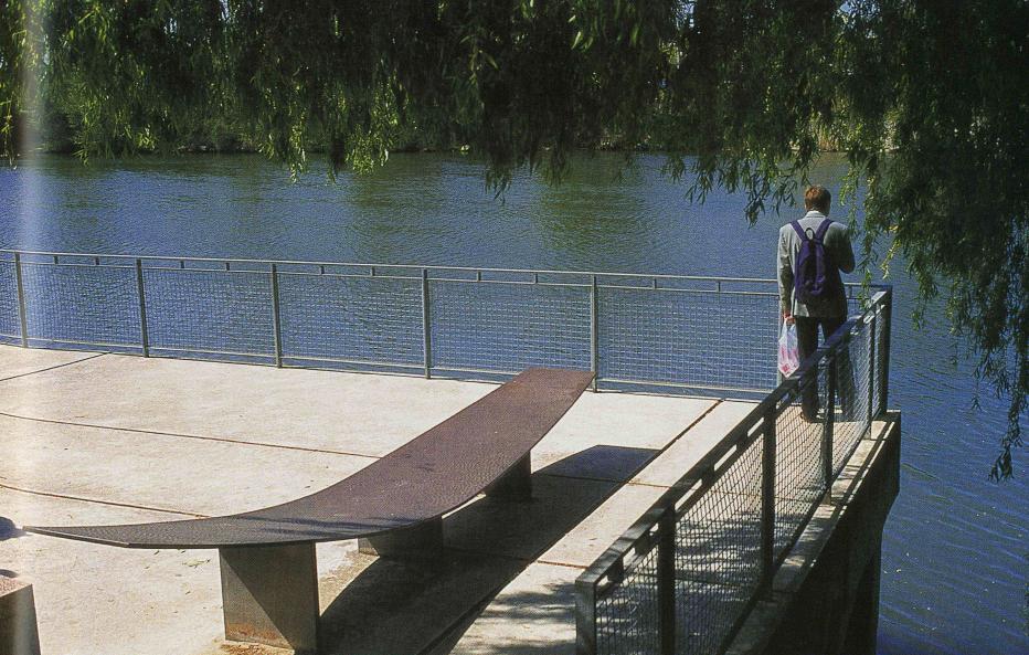 Picture of a man standing on a walkway overlooking a body of water