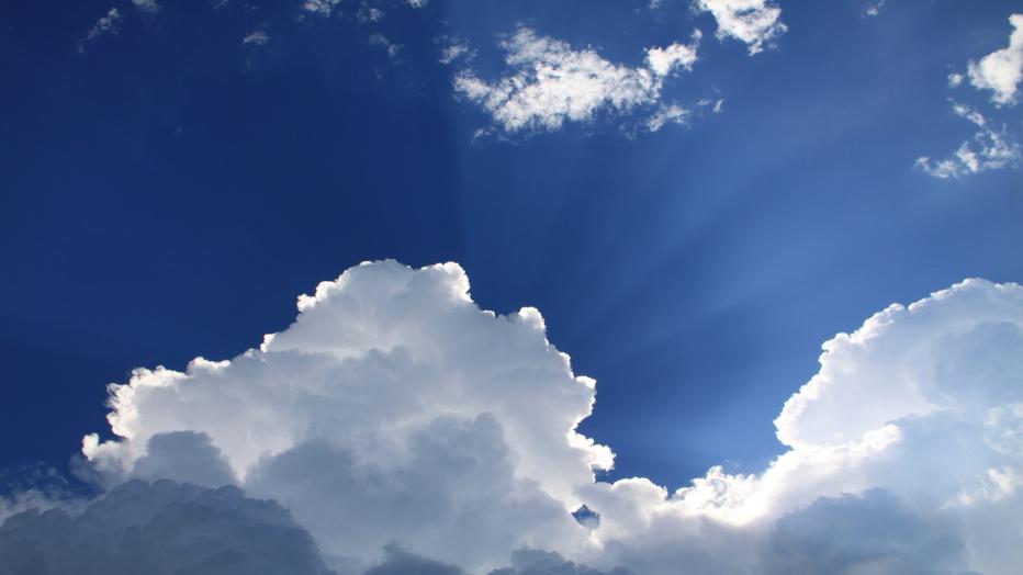 Clouds in front of sun and blue sky