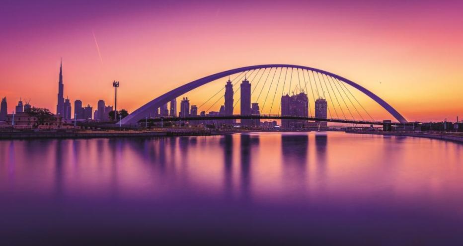 Dubai Water Canal - pink and purple hues with city scape and bridge