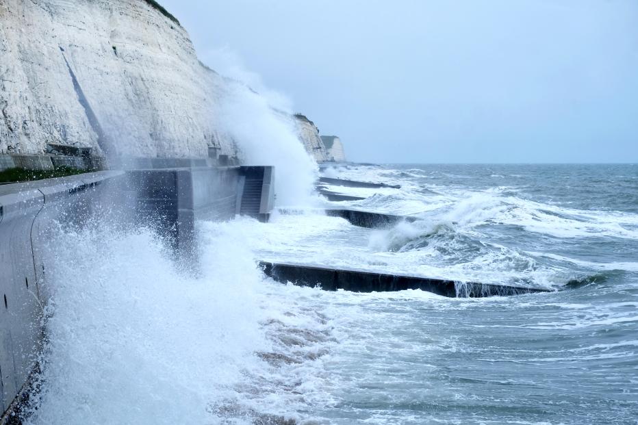 Sea spray and waves hitting coastal walkway