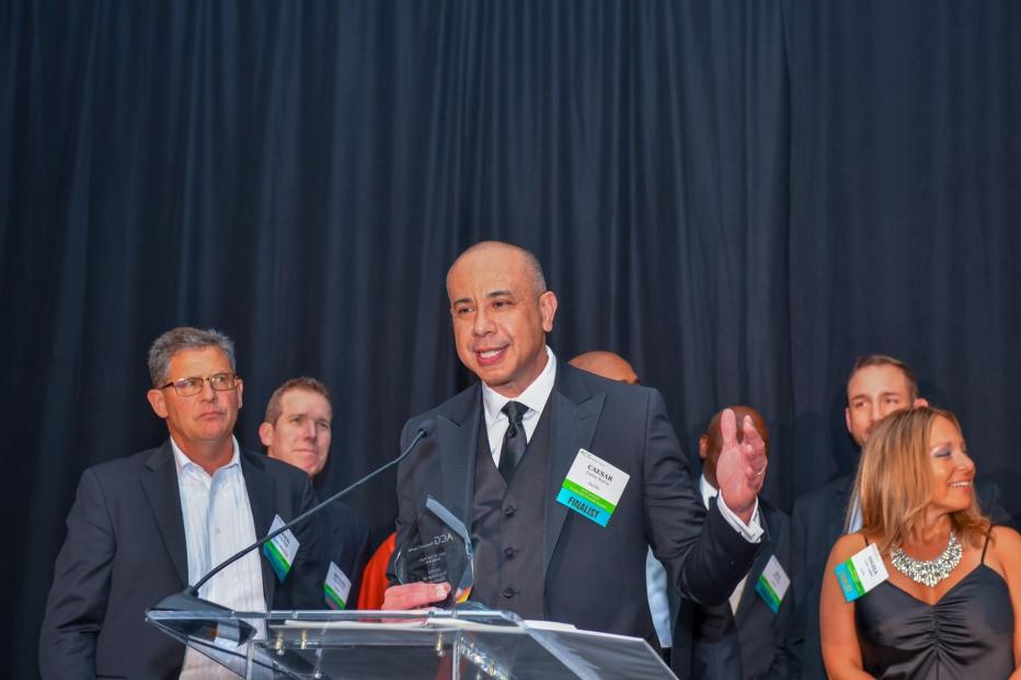 Ceasar Nieves at lectern receiving award on behalf of Jacobs