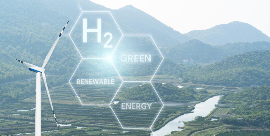 H2; Green; Renewable; Energy; text in honeycomb overlaying arial view of wind turbine over green space.