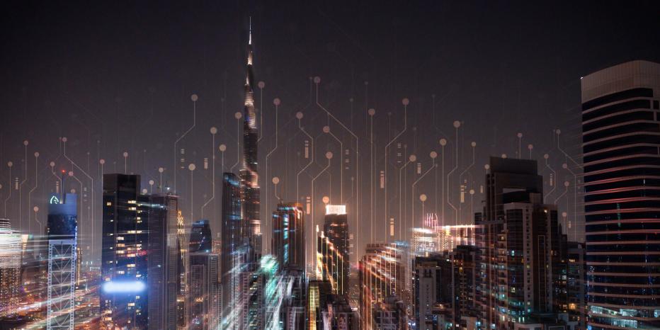 A nighttime cityscape featuring tall, illuminated buildings, overlaid with abstract digital circuit patterns to symbolizing technology and connectedness