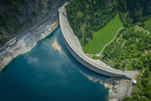 Green lanscape surrounds the dam and water