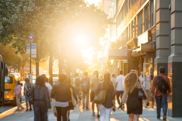 people walking in a city against a sunny background