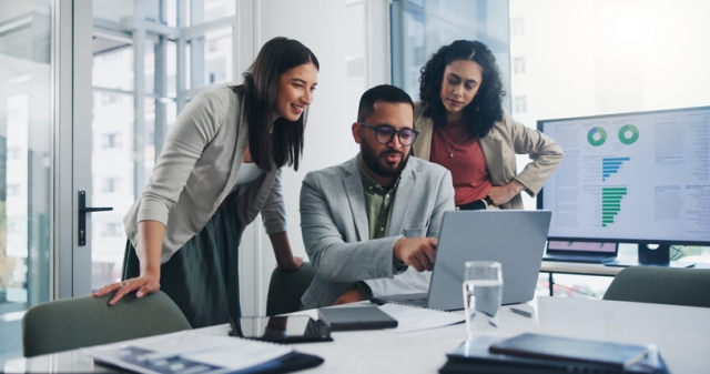 Three people looking at a laptop
