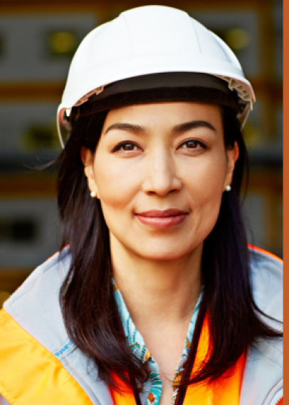 Dark haired woman in a white hard hat and orange PPE