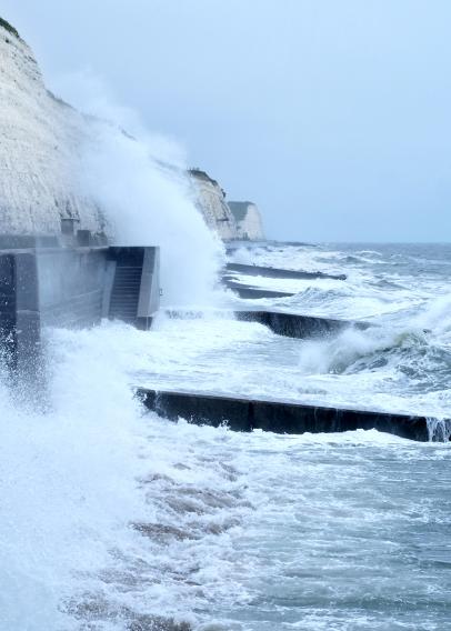 Sea spray and waves hitting coastal walkway