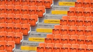 Row of orange empty plastic chairs with staircase